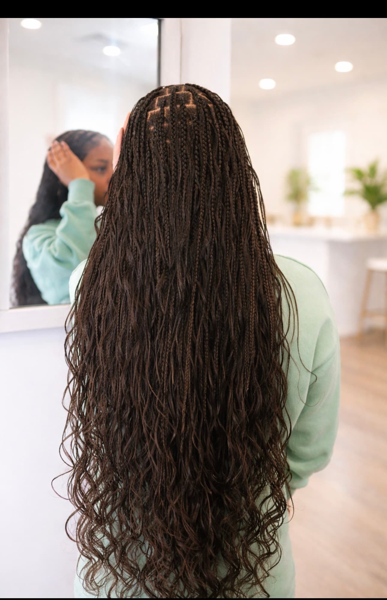 Long dark brown boho box braids with wavy ends on a person seen from behind.